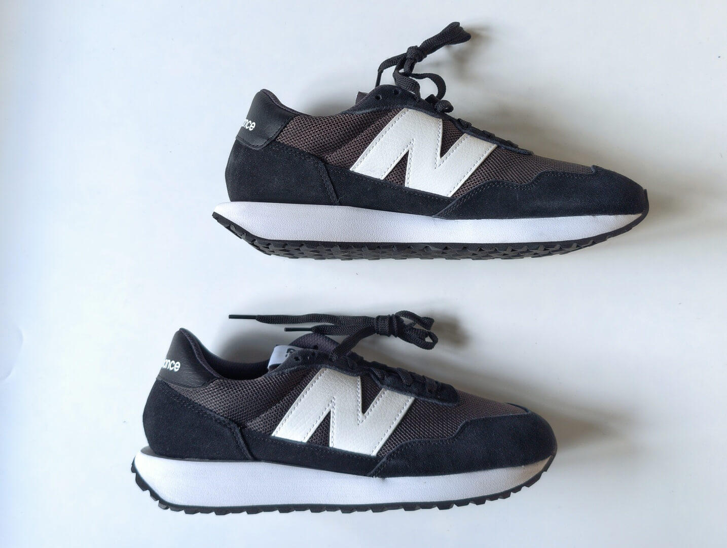Чёрные кроссовки New Balance 237 в профиль: крупная белая N и удлинённая белая подошва