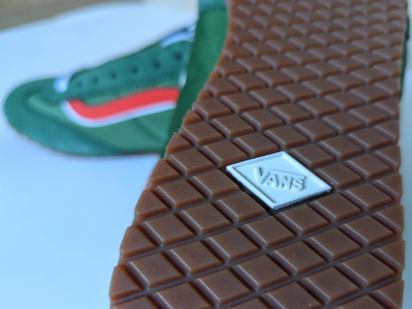Подошва крупно: вафельный протектор цвета камеди и плашка с логотипом Vans